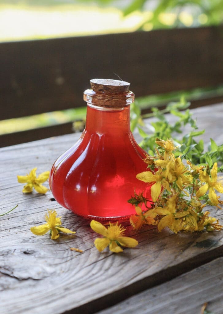 Solar infused St. John's Wort oil on the table